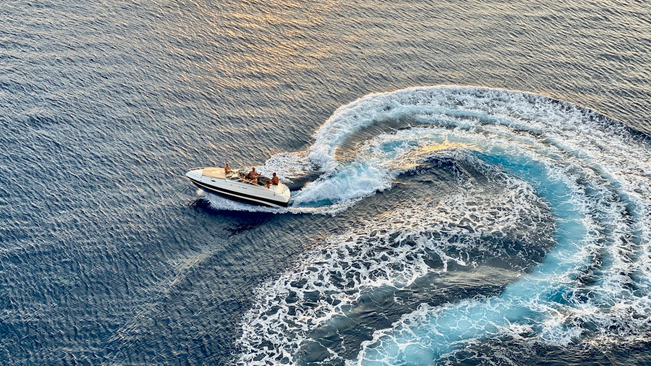 Experience the thrill of a speedboat creating dynamic waves in the Caribbean Sea off Aruba's coast.